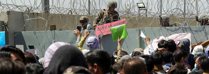 Afghanere prøver at forcere en mur med pigtråd