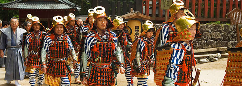 Optog af mennesker klædt som samuraikrigere