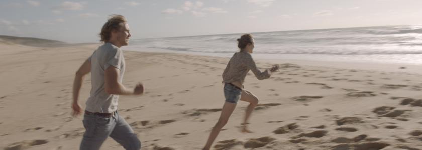 To personer løber på en strand