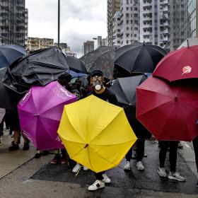 Menneskeflok beskytter sig med paraplyer i Hongkong