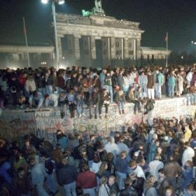 Faktalink: Historiekanon. Mennesker på Berlinmuren ved Brandenburger Tor i natten mellem den 9. og 10. november 1989. Foto: Peter Kneffel / Scanpix